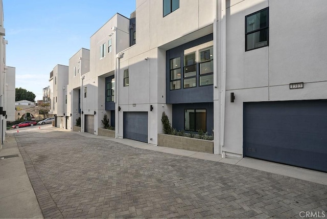 view of property with a garage, a residential view, and driveway