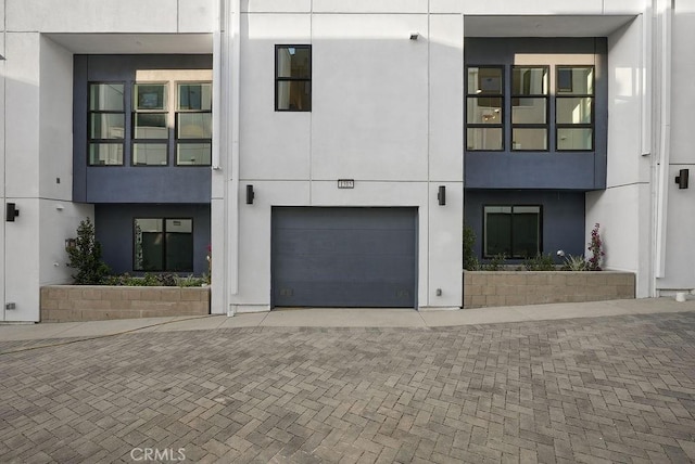 1315 W Cannon Dr, Los Angeles, CA 90026 - view of front of home with an attached garage, decorative driveway, and stucco siding