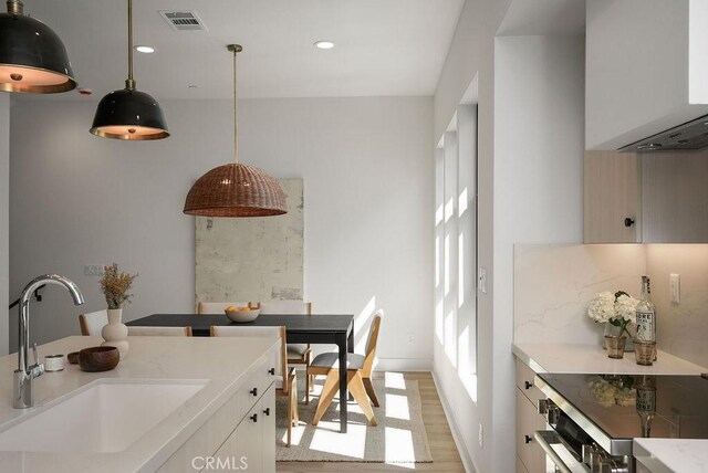 1315 W Cannon Dr, Los Angeles, CA 90026 - kitchen with pendant lighting, light wood-style floors, visible vents, light countertops, and a sink