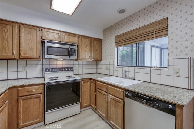 4837 N Hulbert Ave, Fresno, CA 93705 - kitchen featuring stainless steel appliances, wallpapered walls, decorative backsplash, brown cabinets, and light stone counters