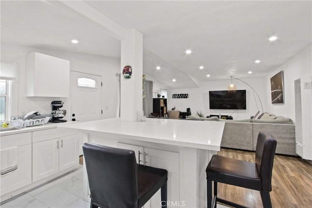 12152 Rosecrans Ave, Norwalk, CA 90650 - kitchen featuring a heating unit, white cabinets, a breakfast bar area, recessed lighting, and open floor plan
