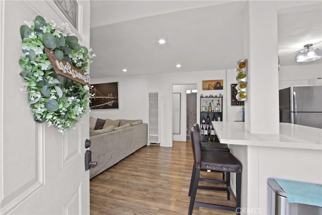 12152 Rosecrans Ave, Norwalk, CA 90650 - kitchen featuring freestanding refrigerator, wood finished floors, a kitchen breakfast bar, recessed lighting, and light countertops