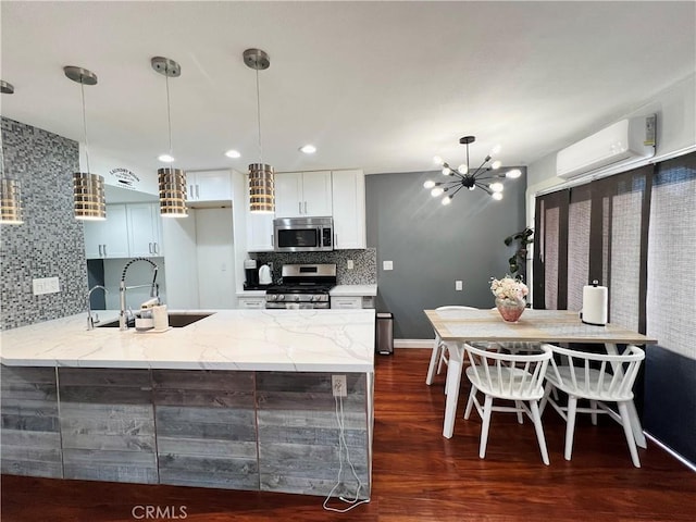 17760 Palo Verde Ave Unit 27, Cerritos, CA 90703 - kitchen with dark wood finished floors, light stone countertops, appliances with stainless steel finishes, a sink, and an AC wall unit