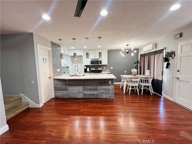 17760 Palo Verde Ave Unit 27, Cerritos, CA 90703 - kitchen featuring a peninsula, a wall mounted AC, appliances with stainless steel finishes, a sink, and decorative backsplash