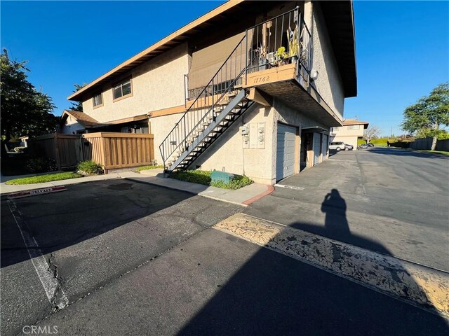 17760 Palo Verde Ave Unit 27, Cerritos, CA 90703 - view of building exterior with fence, stairway, and a garage