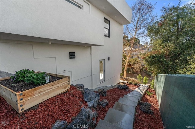 23625 Summit Dr, Calabasas, CA 91302 - view of side of property with a vegetable garden, stucco siding, and fence
