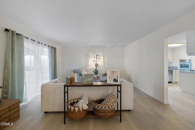 living area featuring light wood finished floors and baseboards