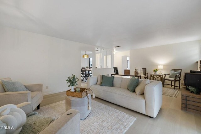living area featuring baseboards and wood finished floors