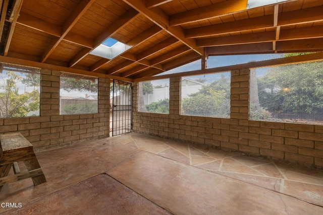 unfurnished sunroom with plenty of natural light and beam ceiling