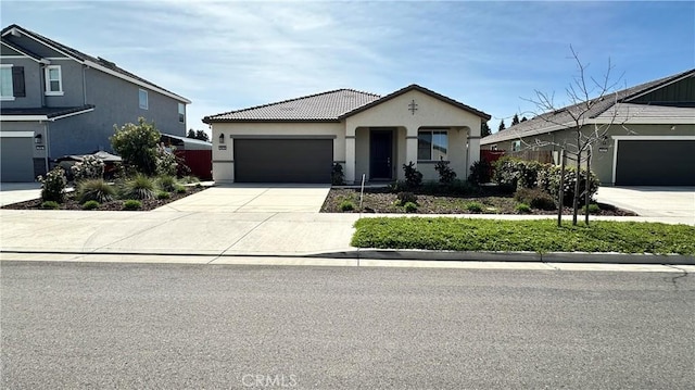 2428 Freestone Dr, Merced, CA 95340 - view of front facade with stucco siding, an attached garage, concrete driveway, and a tile roof