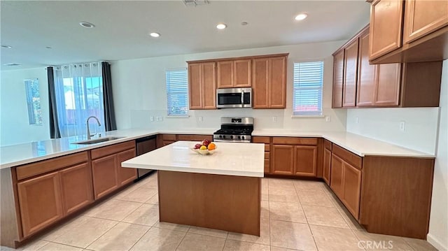 kitchen with light countertops, a sink, appliances with stainless steel finishes, a peninsula, and recessed lighting