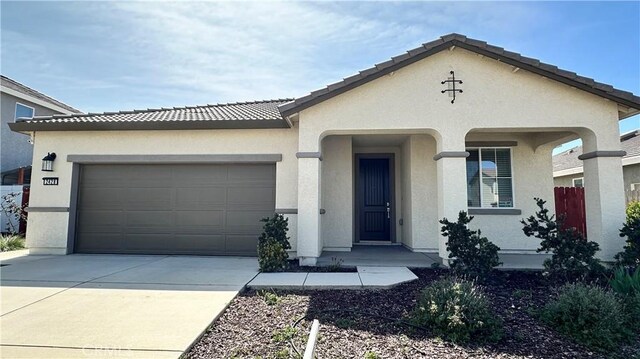 2428 Freestone Dr, Merced, CA 95340 - view of front facade featuring concrete driveway, a garage, stucco siding, and a tiled roof