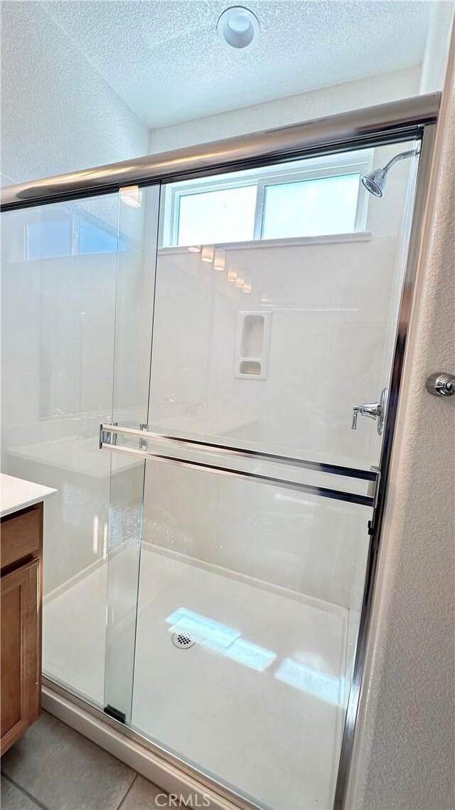 2428 Freestone Dr, Merced, CA 95340 - full bathroom with a shower stall, vanity, a textured ceiling, and tile patterned floors