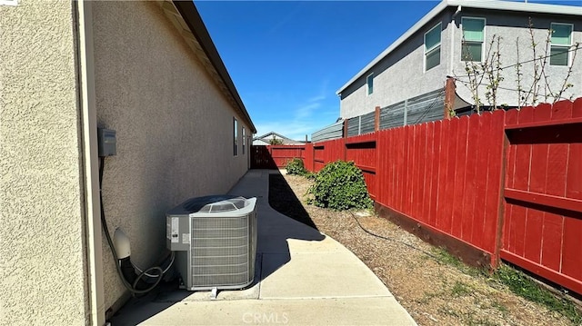 view of yard with a fenced backyard and central AC
