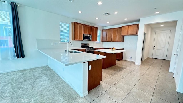 2428 Freestone Dr, Merced, CA 95340 - kitchen with stainless steel appliances, brown cabinets, recessed lighting, light countertops, and a peninsula