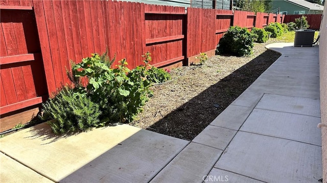 view of yard featuring a patio, central air condition unit, and a fenced backyard