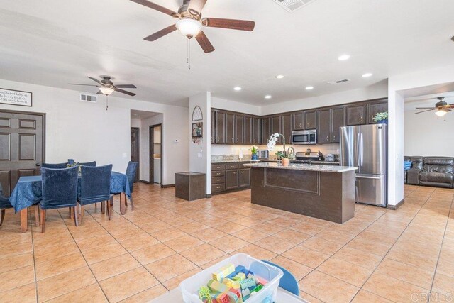400 Colt St, San Jacinto, CA 92582 - kitchen featuring stainless steel appliances, open floor plan, dark brown cabinetry, a ceiling fan, and light tile patterned floors