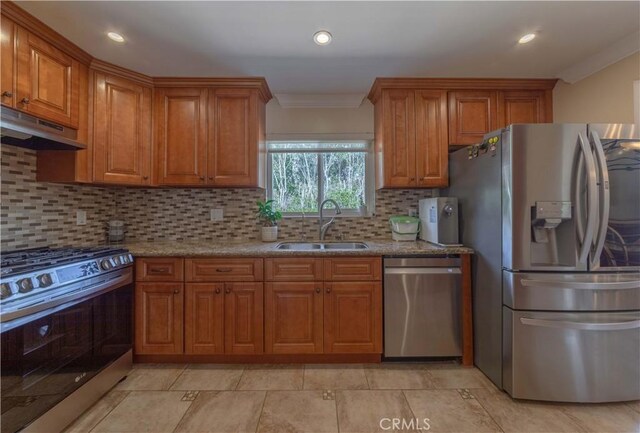 1516 W 5th St, San Pedro, CA 90732 - kitchen with stainless steel appliances, under cabinet range hood, brown cabinets, decorative backsplash, and ornamental molding
