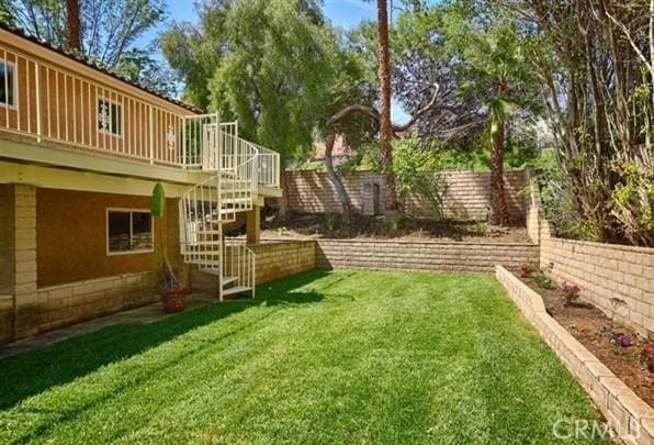view of yard featuring a deck, stairs, and a fenced backyard