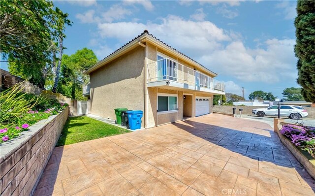 1516 W 5th St, San Pedro, CA 90732 - view of property exterior with a balcony, driveway, stucco siding, and an attached garage