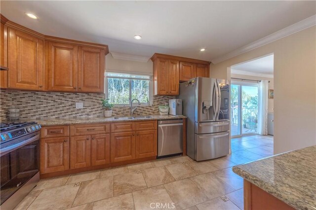 1516 W 5th St, San Pedro, CA 90732 - kitchen featuring stainless steel appliances, ornamental molding, brown cabinets, tasteful backsplash, and light stone counters