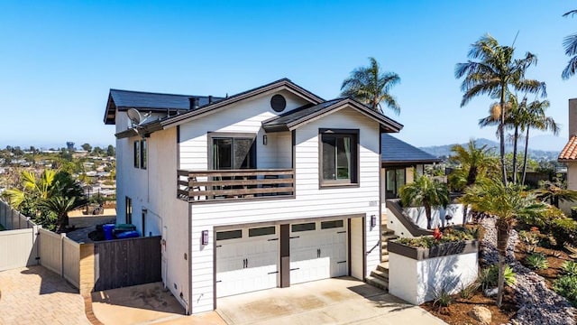 8089 Wing Span Dr, San Diego, CA 92119 - view of front of house with fence, concrete driveway, a balcony, and a garage