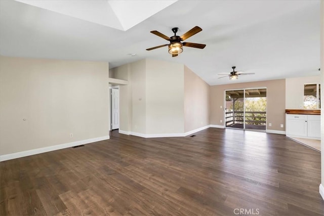 unfurnished living room featuring lofted ceiling with skylight, a ceiling fan, baseboards, and dark wood finished floors