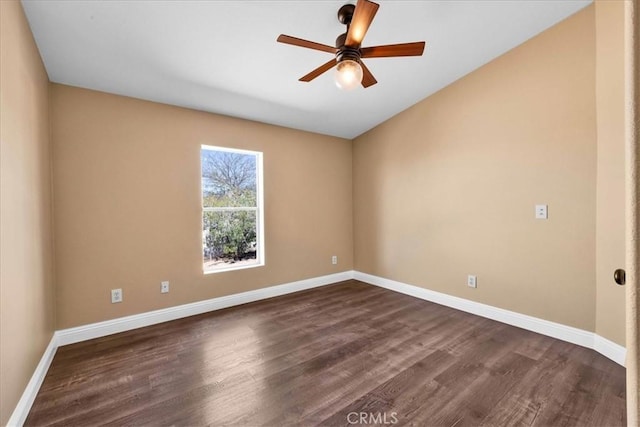 spare room with dark wood-type flooring and baseboards