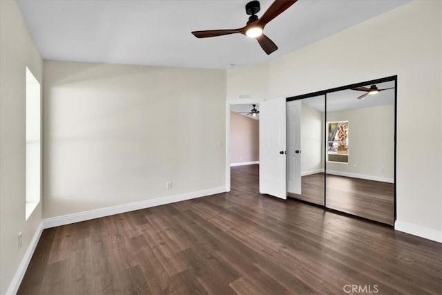 unfurnished bedroom featuring a ceiling fan, a closet, baseboards, and wood finished floors