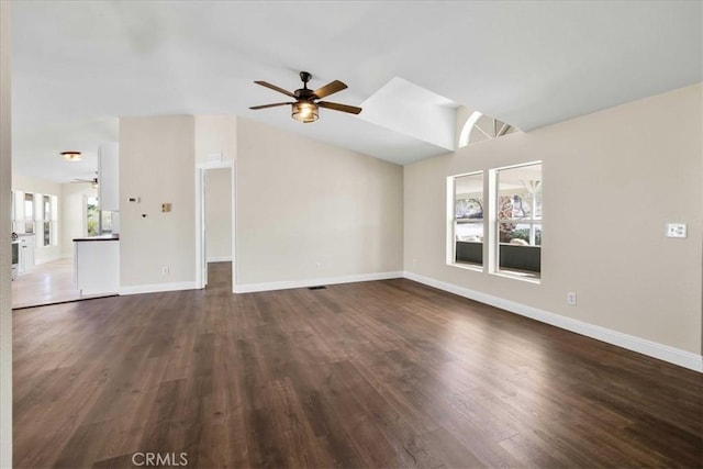 unfurnished living room with a ceiling fan, baseboards, lofted ceiling, and dark wood finished floors