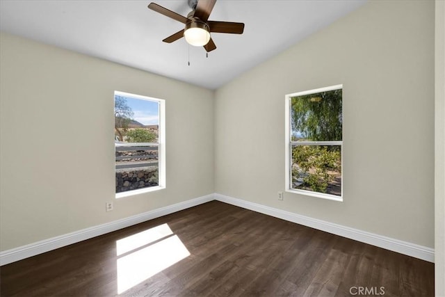 unfurnished room featuring baseboards, vaulted ceiling, ceiling fan, and dark wood-style floors