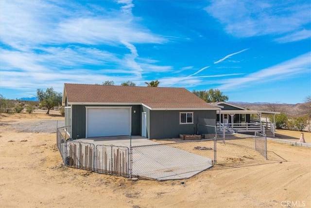 ranch-style house with driveway, a garage, and fence private yard