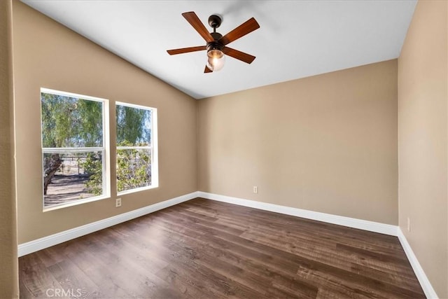 spare room with baseboards, dark wood-style floors, lofted ceiling, and ceiling fan