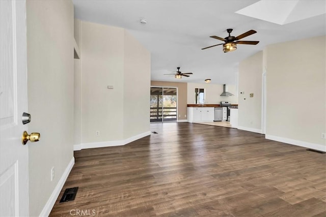 unfurnished living room featuring a ceiling fan, a skylight, baseboards, and wood finished floors