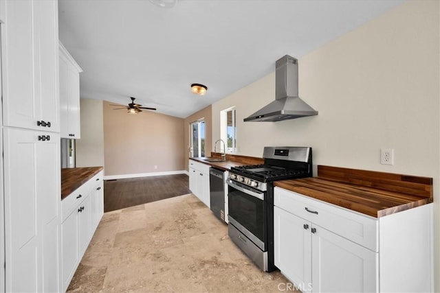 kitchen featuring gas stove, a sink, wood counters, dishwasher, and wall chimney range hood