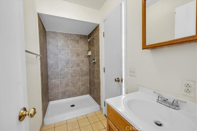 full bath with tile patterned floors, a tile shower, and vanity