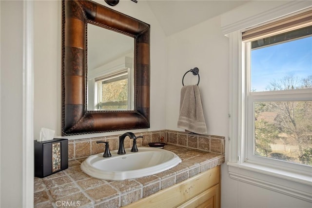 bathroom with lofted ceiling and vanity