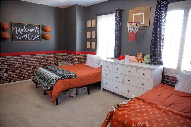 bedroom with brick wall, carpet, and multiple windows