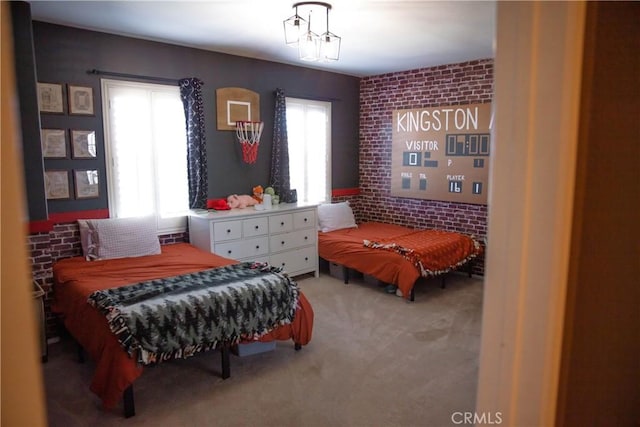 bedroom featuring light colored carpet and brick wall