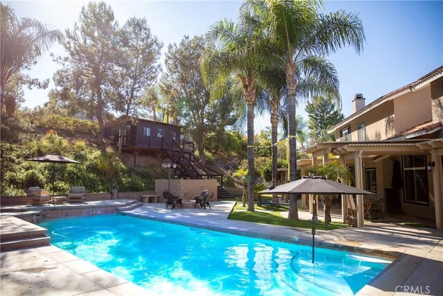 pool with a pergola and a patio