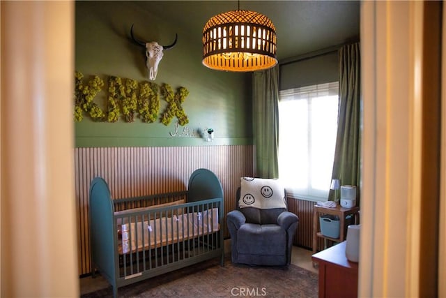 bedroom featuring carpet flooring and a nursery area