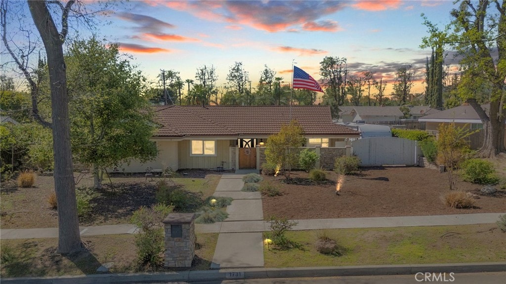 1731 N 1st Ave, Upland, CA 91784 - view of front of home with a tile roof, fence, and a gate