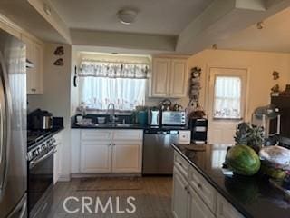 9394 Kempster Ave, Fontana, CA 92335 - kitchen with dark countertops, a wealth of natural light, and stainless steel appliances