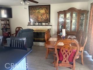 9394 Kempster Ave, Fontana, CA 92335 - dining area with wood finished floors, a fireplace, and a ceiling fan