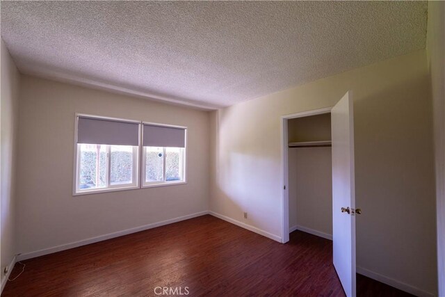 12821 Salisbury St, Baldwin Park, CA 91706 - unfurnished bedroom featuring a textured ceiling, a closet, baseboards, and dark wood finished floors