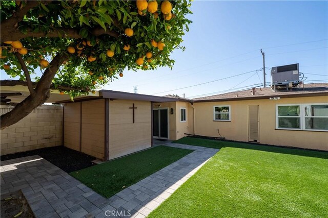 12821 Salisbury St, Baldwin Park, CA 91706 - rear view of house with central AC unit, a patio area, a yard, fence, and stucco siding