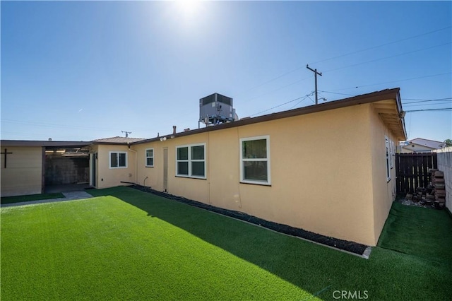 12821 Salisbury St, Baldwin Park, CA 91706 - back of house featuring fence, central air condition unit, a lawn, and stucco siding
