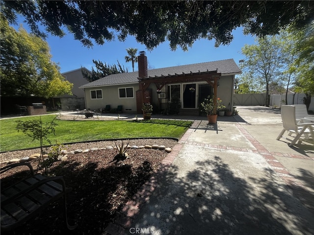 back of property featuring a pergola, a fenced backyard, a chimney, a patio, and a yard
