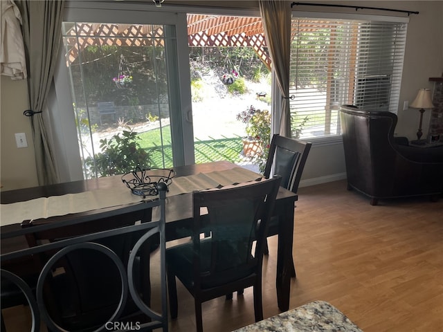 dining area featuring baseboards and light wood-type flooring