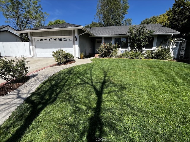 ranch-style house with fence, a front lawn, a garage, stucco siding, and driveway